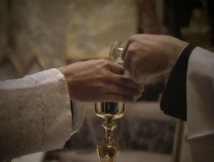 Wine and water are poured over the priest's fingers into the chalice.
