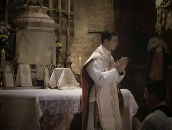 The priest at the altar with the server kneeling below.