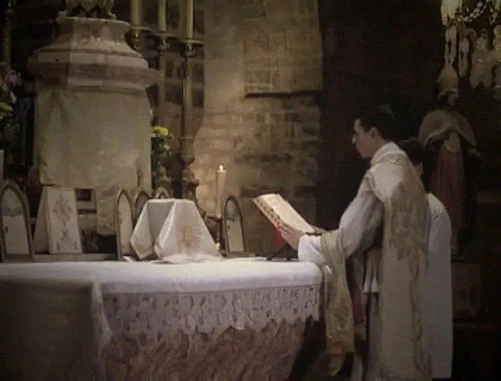 The priest reads at the missal on the Epistle side.