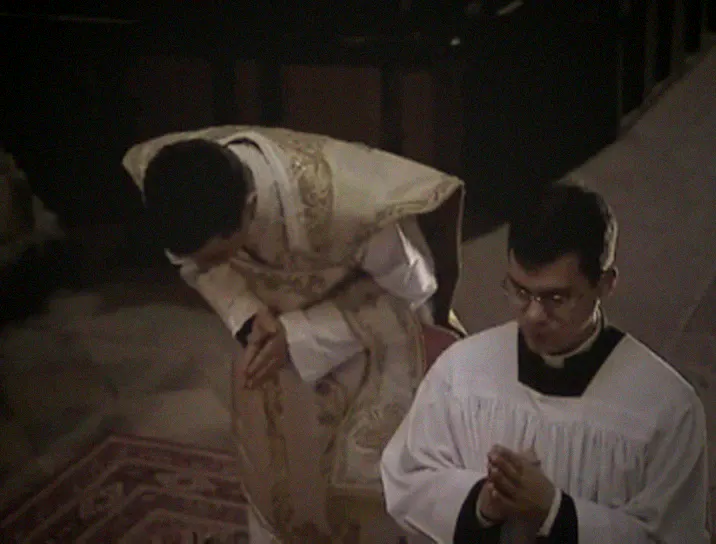 The priest bows low at the foot of the altar for the Confiteor while the server kneels.